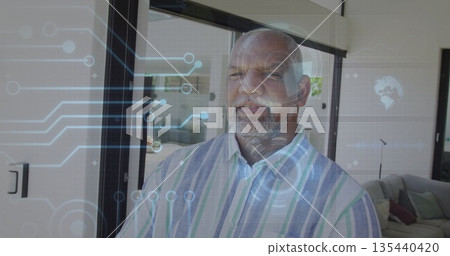 Standing man wearing striped shirt in living room, with holographic overlays on sliding glass doors 135440420