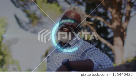 Smiling senior man leaning against wooden railing in garden, with checkered shirt and wristwatch Smiling senior man leaning against wooden railing in garden, with checkered shirt and wristwatch 135440423