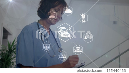 Nurse in scrubs recording in clinic hall with clipboard pen stethoscope floating icons, copy space Nurse in scrubs recording in clinic hall with clipboard pen stethoscope floating icons, copy space 135440433
