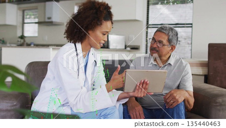 Discussing doctor pointing at tablet screen toward patient on sofa in living room, with stethoscope Discussing doctor pointing at tablet screen toward patient on sofa in living room, with stethoscope 135440463