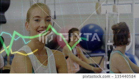 Rowing blonde woman smiling at camera in gym studio, with stability balls, data overlay, copy space 135440584