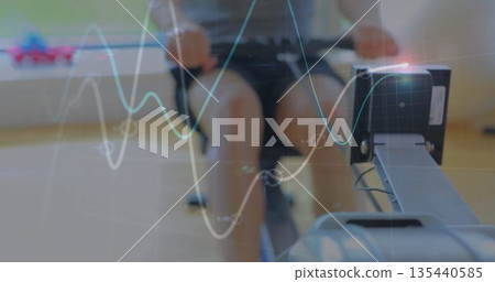 Rowing fit man pulling handlebar on rowing machine at fitness room, with digital display overlays 135440585