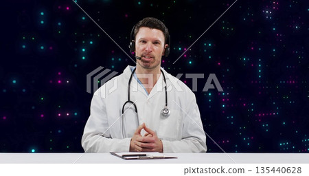 Speaking doctor wearing lab coat and headset mic at telemedicine set with clipboard pen stethoscope Speaking doctor wearing lab coat and headset mic at telemedicine set with clipboard pen stethoscope 135440628