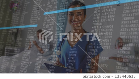 Standing female medical team with stethoscopes reviewing tablet in hospital hall, with code overlay 135440633