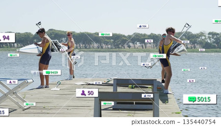 Lifting shell and adjusting oars, rowers wearing yellow navy uniforms training on dock near bench 135440754