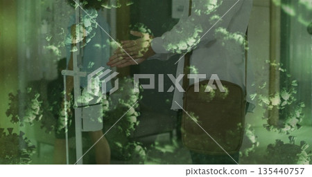 Shaking hands between doctor and patient carrying bag through partition in clinic, with virus Shaking hands between doctor and patient carrying bag through partition in clinic, with virus 135440757