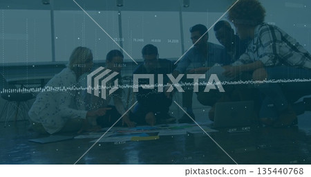 Leaning coworkers reviewing colorful charts on modern office floor, with digital waveform overlay Leaning coworkers reviewing colorful charts on modern office floor, with digital waveform overlay 135440768