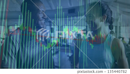 Standing two gym-goers smiling and talking in gym, with financial chart overlay and treadmills 135440782