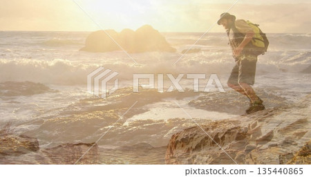 Balancing hiker wearing hat and boots on shoreline at sunset, with backpack, tide pools, copy space Balancing hiker wearing hat and boots on shoreline at sunset, with backpack, tide pools, copy space 135440865