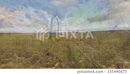 Traversing hiker wearing wide-brimmed hat on semi-arid plain, with backpack and trekking pole Traversing hiker wearing wide-brimmed hat on semi-arid plain, with backpack and trekking pole 135440873