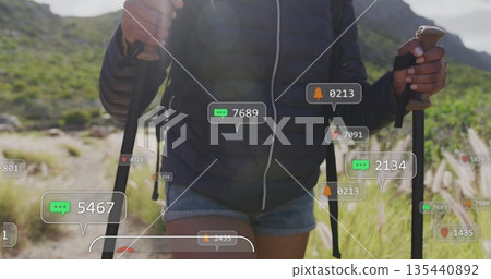 Walking female hiker navigating rocky mountain trail, with trekking poles and social media icons Walking female hiker navigating rocky mountain trail, with trekking poles and social media icons 135440892