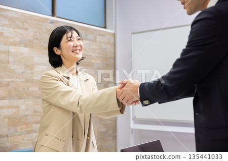 微笑的男女商務人士握手 135441033