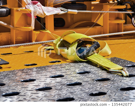 Yellow strap lies on work platform near industrial equipment in construction site during daylight hours 135442077