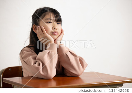 An elementary school girl with a bored look on her face An elementary school girl with a bored look on her face 135442968