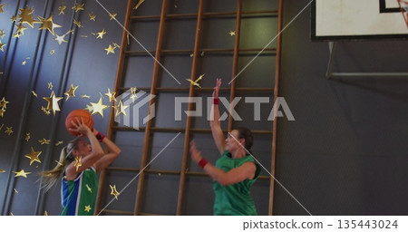 Shooting basketball player in blue uniform releasing ball in gym, hoop, wall bars and star graphics Shooting basketball player in blue uniform releasing ball in gym, hoop, wall bars and star graphics 135443024