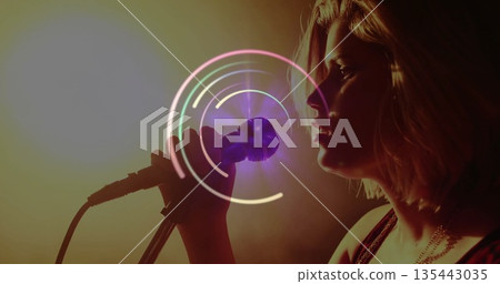 Singing singer performing with handheld microphone and circular overlay on dark stage, copy space Singing singer performing with handheld microphone and circular overlay on dark stage, copy space 135443035