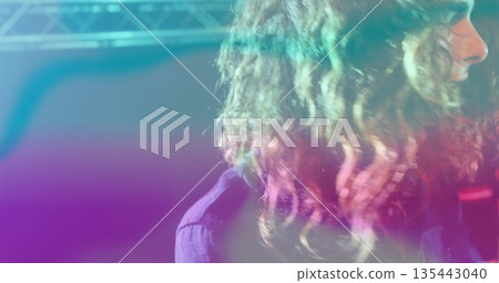Performing side-profile musician glowing under neon lights on stage, with steel truss, copy space 135443040