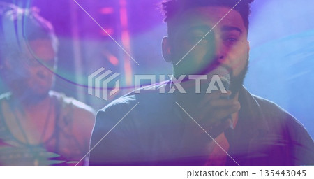 Singing singer wearing casual shirt gripping microphone on concert stage, with drum kit and trusses Singing singer wearing casual shirt gripping microphone on concert stage, with drum kit and trusses 135443045