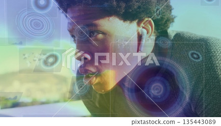 Running male athlete wearing running top on sunlit path, with wireless earphones and HUD overlay 135443089