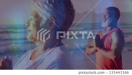 Praying woman in white T-shirt pressing hands together on sandy beach, with partner, copy space 135443166