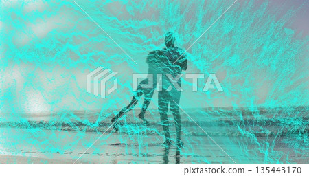 Swinging man and child playing at ocean shoreline, with wet sand and gentle waves 135443170