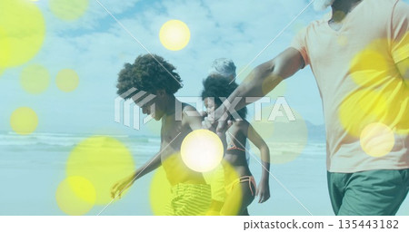 Walking extended family holding hands along sandy beach shore, with soft light flares Walking extended family holding hands along sandy beach shore, with soft light flares 135443182