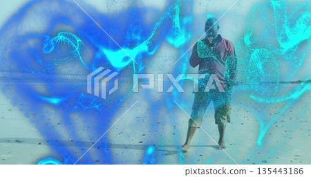 Talking senior man holding smartphone at sandy shore, with cyan digital particles, copy space Talking senior man holding smartphone at sandy shore, with cyan digital particles, copy space 135443186