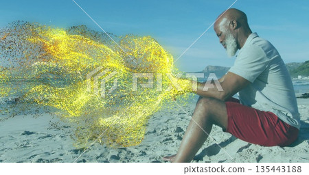 Man in red shorts creating golden digital swirl on sandy beach by ocean surf, copy space Man in red shorts creating golden digital swirl on sandy beach by ocean surf, copy space 135443188