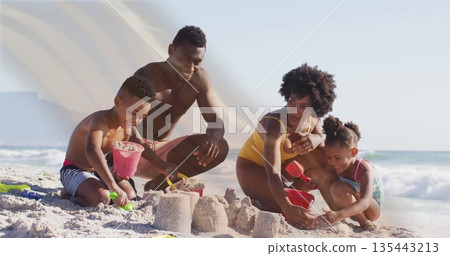 Building family in swimwear kneeling on beach shaping sandcastles with buckets, shovels and molds Building family in swimwear kneeling on beach shaping sandcastles with buckets, shovels and molds 135443213