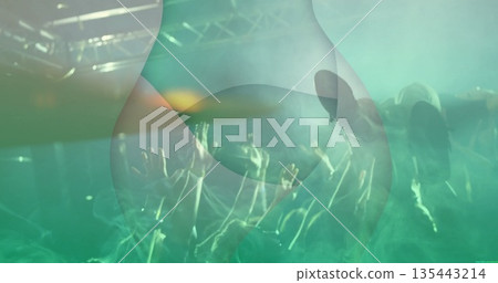 Crowdsurfing silhouette person floating above concert crowd with metal truss and lighting fixtures 135443214