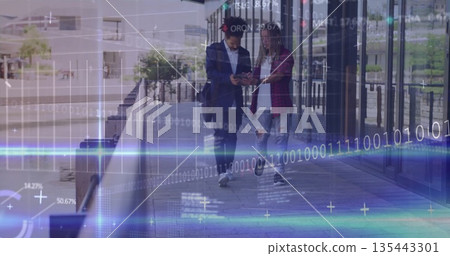 Walking two colleagues comparing data on smartphone at urban riverside walkway, with binary overlay Walking two colleagues comparing data on smartphone at urban riverside walkway, with binary overlay 135443301