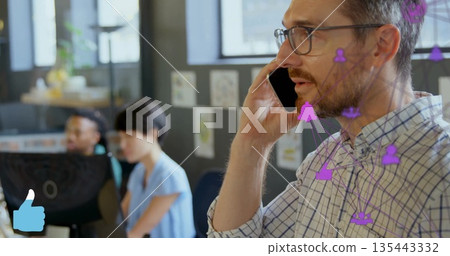 Calling man wearing glasses and checked shirt with smartphone in modern office, with network icons 135443332
