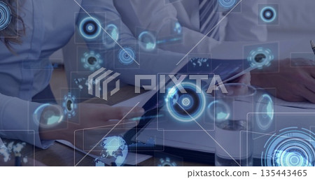 Coworkers reviewing documents and tablet on office table, with pen, water and holographic interface Coworkers reviewing documents and tablet on office table, with pen, water and holographic interface 135443465