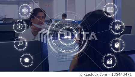 Projecting network interface overlaying workers in business attire at open-plan office, with icons Projecting network interface overlaying workers in business attire at open-plan office, with icons 135443471