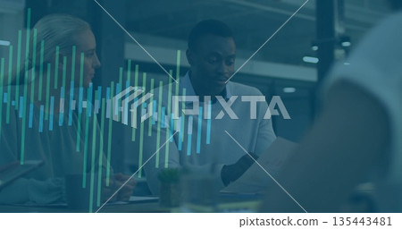 Reviewing mid adult man in sweater examining printed documents in office, with chart overlays Reviewing mid adult man in sweater examining printed documents in office, with chart overlays 135443481