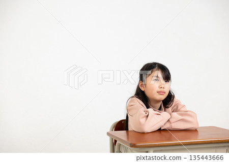 小學女生雙手抱胸坐在課桌前 135443666