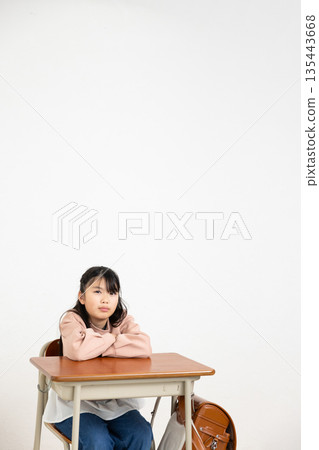 小學女生雙手抱胸坐在課桌前 135443668