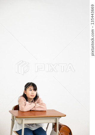 小學女生雙手抱胸坐在課桌前 135443669