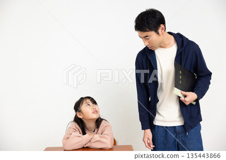 一位男老師和一位小學生在教室裡交談 135443866