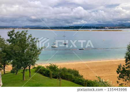 Wonderful view of the calm sea from the promenade in Santander, Spain, with soft waves and a peaceful coastal atmosphere. Wonderful view of the calm sea from the promenade in Santander, Spain, with soft waves and a peaceful coastal atmosphere. 135443996