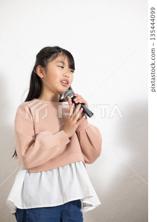 小學生女孩拿著麥克風唱歌 135444099