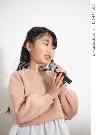 小學生女孩拿著麥克風唱歌 135444100