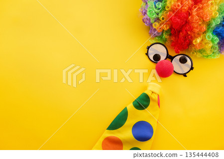 Clown costume elements on yellow background with copy space 135444408