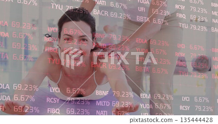 Holding plank woman in activewear with partner supporting shoulders on studio mats, ticker overlay Holding plank woman in activewear with partner supporting shoulders on studio mats, ticker overlay 135444428