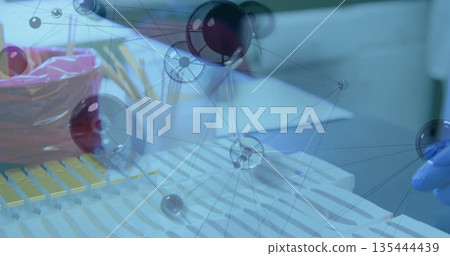 Showing yellow pipette rack on lab bench with red bag, pencils, papers, glove and network overlay Showing yellow pipette rack on lab bench with red bag, pencils, papers, glove and network overlay 135444439