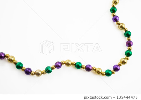 Mardi gras beads string forming a colorful diagonal border 135444473