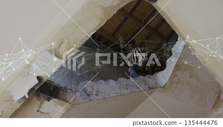 Climbing man gripping beam amid debris in damaged ceiling, with digital network overlay, copy space 135444476