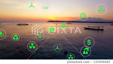 Floating green renewable energy icons over coastal sea at sunset, with wooden fishing boats Floating green renewable energy icons over coastal sea at sunset, with wooden fishing boats 135444485