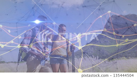 Hikers walking with backpacks, boots, trekking pole, water bottle across grassy plain data overlay 135444504