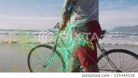 Man wearing white T-shirt red trunks holding bicycle on beach, with digital particles, copy space Man wearing white T-shirt red trunks holding bicycle on beach, with digital particles, copy space 135444526